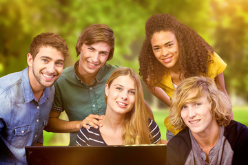 Obraz premium College students using computer against trees and meadow