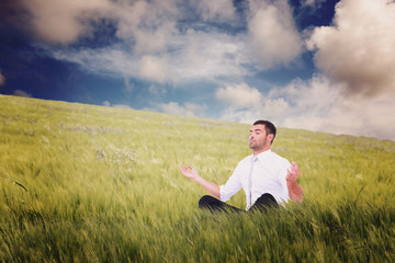 Naklejka na ściany i meble Businessman meditating in lotus pose against nature scene