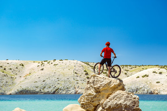 Mountain biker looking at mountains and beach