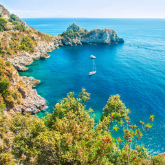 petite baie avec des bateaux en mer Égée entourée de rochers
