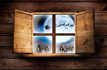 Window in wooden room against santa delivery presents to village