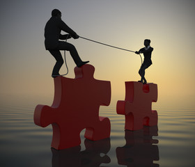 Team pulling huge jigsaw puzzle into position at sea at dawn. Two executives pull huge jigsaw puzzle pieces into position demonstrating teamwork at sea since dawn.