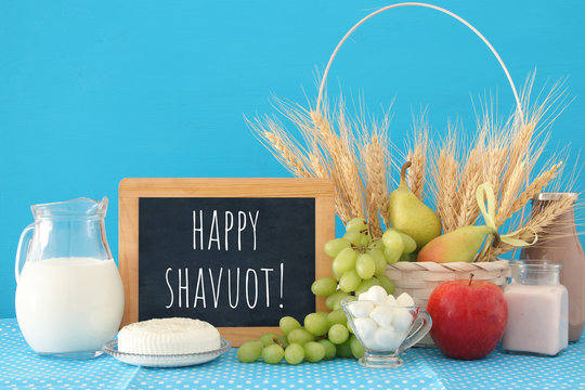 image of dairy products and fruits over wooden table. Symbols of jewish holiday - Shavuot.