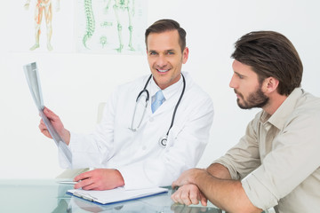 Smiling doctor explaining spine xray to patient