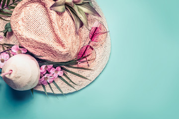 Summer holiday . Beach accessories : straw hat, palm leaves, pink sun glasses, flowers and coconut cocktail on blue turquoise background, top view. Tropical vacation travel concept