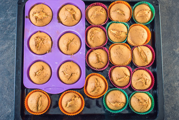 Homemade freshly made cupcakes in silicone molds on dark background. Top view. Concept of confectionery cooking