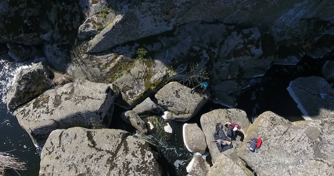 Two сlimber prepare equipment for climbing rock among granite canyon Aerial view