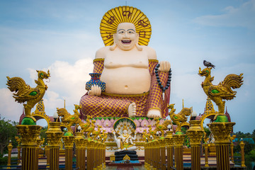 Giant smiling or happy buddha statue in buddhist temple ( wat plai laem ), Koh Samui, Thailand.