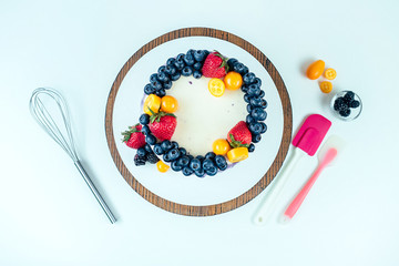 appetizing and berry wedding cake on a white background on the table. view from above . confectioner, cake, cooking. wedding and birthday cake with berries (strawberries, blueberries, berries)