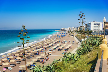 Aegean beach with sunshades in city of Rhodes (Rhodes, Greece)