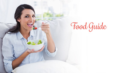 The word food guide against cheerful woman relaxing on the sofa eating salad