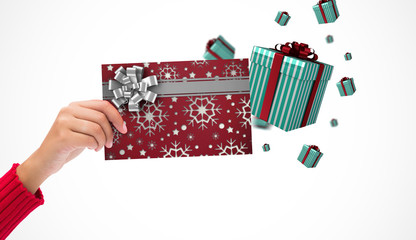 Fototapeta na wymiar Hand holding card against christmas wrapping paper with bow