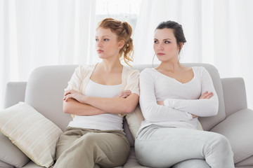 Unhappy friends not talking after argument on the couch