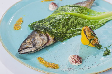 Fish with lettuce on the turquoise plate