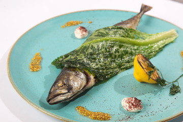 Fish with lettuce on the turquoise plate