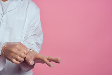 man gesticulates with his hands on a pink background