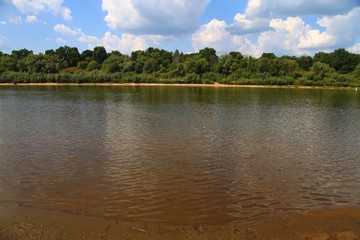 Small river in the netherland (friesland), against a partial clouded sky