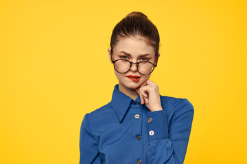 woman in blue shirt bit her lip on a yellow background