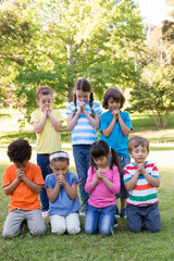 Fototapeta na wymiar Children saying their prayers in park