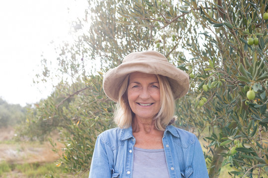 Portrait of happy woman standing in olive farm