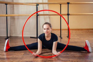 stretching girl with red hoop in the gym