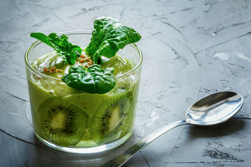 Green fresh smoothies with kiwi and spinach on gray background. Detox concept. Vegan