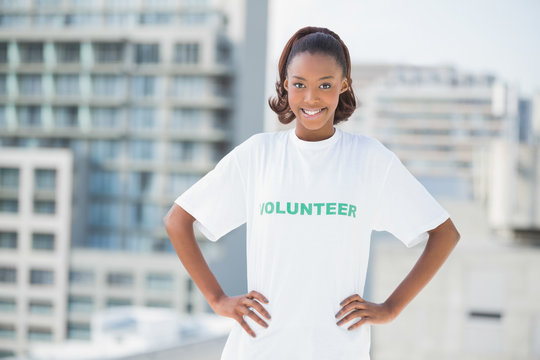 Smiling woman with hands on hips wearing volunteer tshirt