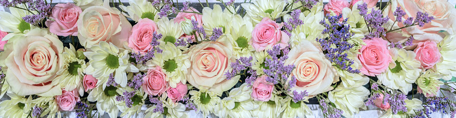 Horizontal flower arrangement. Delicate tea-hybrid roses of pink color and white the chamomile chrysanthemums with a green core, Bacardi variety.