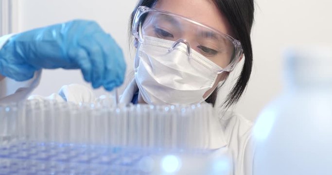 Asian scientist doing experiment with test tubes