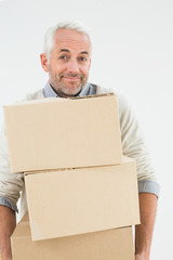 Portrait of a smiling mature man carrying boxes