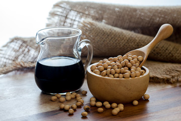 Soy sauce and soy bean on wooden 