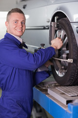 Smiling mechanic changing a car wheel