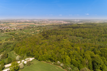 Luftbild mit Blick üner den Wald auf die Felderebene