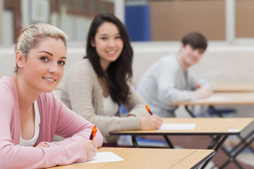 Fototapeta premium Students looking up from exam and smiling