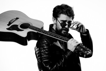 man with a guitar in his hand and in glasses leather jacket