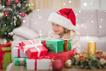 Obraz na płótnie Canvas Cute little girl surrounded by christmas gifts against snow