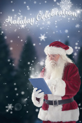 Naklejka premium Santa uses a tablet PC against fir tree forest