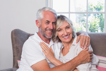 Mature man embracing woman on couch
