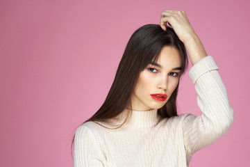 Fototapeta premium woman on a pink background touches her head