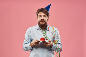 man with a cake on a pink background