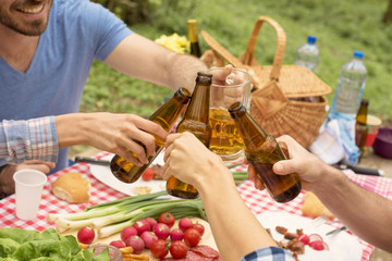 Group of friends enjoying picnic day and eating barbecue together