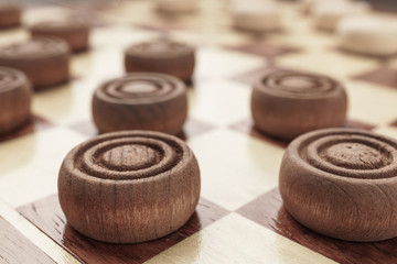 wooden draughts board game on brown table