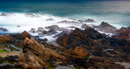 At dawn the waves of the sea break on the rocks