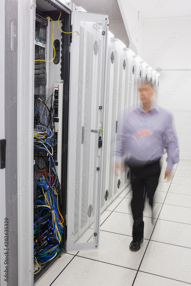 Poster Man walking towards open server tower