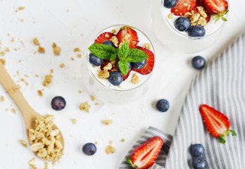 Healthy Breakfast Concept. Muesli with Greek Yogurt, Strawberries and Blueberries, Diet, Summer Food. White Background, Close-up, Flat lay
