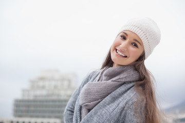 Smiling pretty brunette with winter clothes on posing