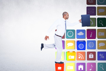 Businessman running with briefcase against grey room