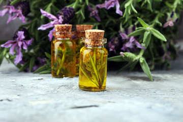 lavender oil in a glass bottle on a background of fresh flowers.