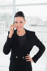 Smiling elegant businesswoman using cellphone