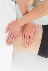 Mid section of a physiotherapist massaging womans body